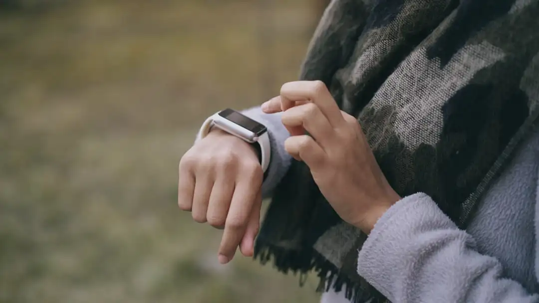 Person checking smartwatch for health monitoring representing wearable health technology