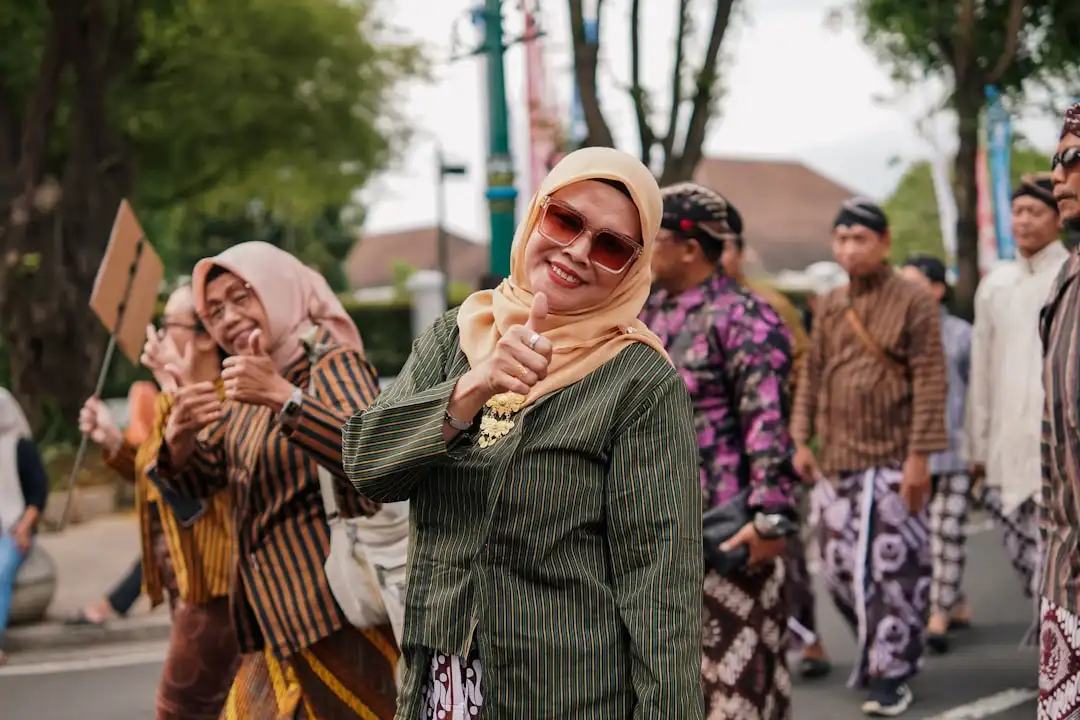 Indonesian woman in green kebaya and hijab giving thumbs up representing women empowerment and leadership